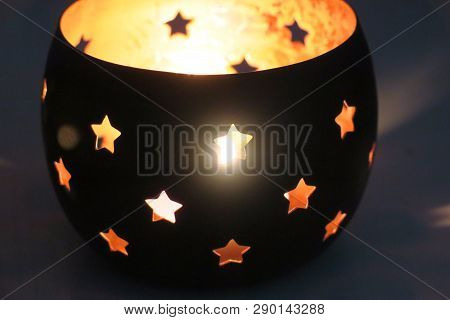 Candlestick With Black Stars Radiating Light From Inside