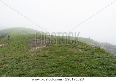 Small Distant Figure Of Unregognisable Person On Hilltop In Fog Before Sunrise At Katiki Point Moera