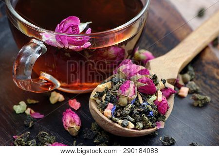 A Cup Of Tea. Green Tea With Flowers In A Wooden Spoon On A Dark Wooden Table. Green Tea With Flower