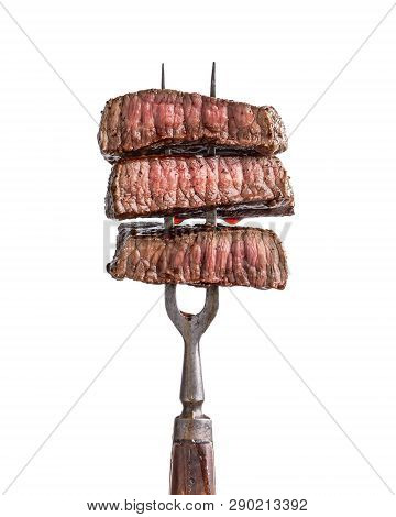 Slices Of Beef Steak On Vintage Fork Isolated On White