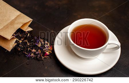Elicious Tea In A White Mug, Scattered Tea From The Package On A Stone Background