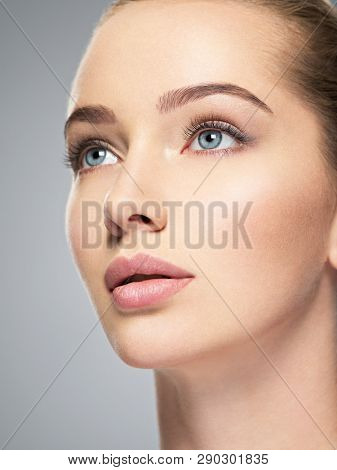 Beautiful face of young caucasian woman with perfect health clean skin.  Skin care treatment. Profile Portrait of an Attractive girl  with blue eyes, closeup.