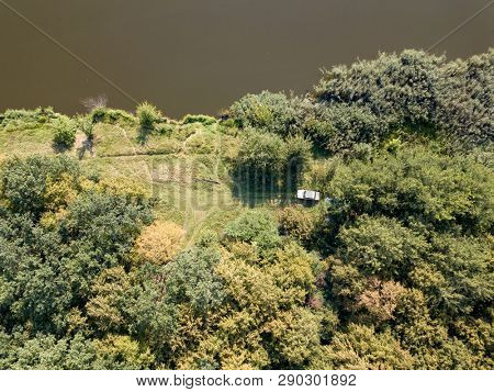 Natural ladscape with dreen trees, river bank, white car on a meadow. Aerial view from drone. Top view.