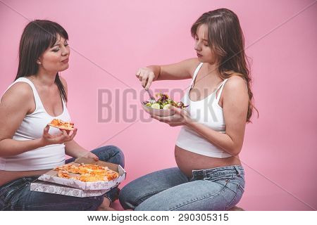 Nutrition Concept, Pregnant Women Eating Pizza On A Pink Background