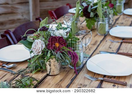 Table scape with dark red florals and wood accents
