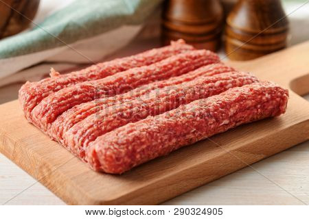 Close up of row of fresh raw beef kebabs