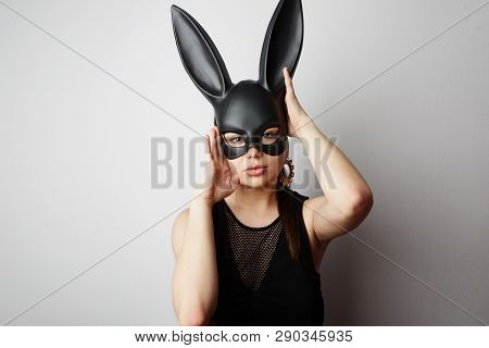 Sexy Young Woman With Red Lipstick And Large Breasts Wearing A Black Mask. Easter Bunny Standing On 