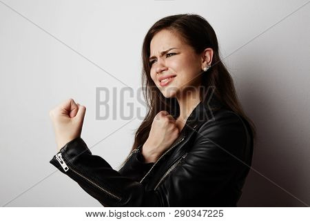 Fashion Photo Of A Beautiful Brunette Woman Wearing Leather Jacket With Dark Long Hair Posing Over W