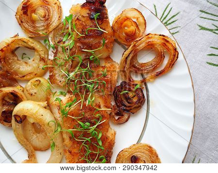 Grilled Fish On White Plate With Onions And Micro Greens