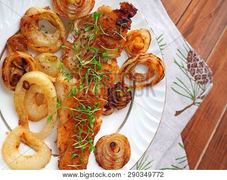 Grilled Fish On White Plate With Onions And Micro Greens