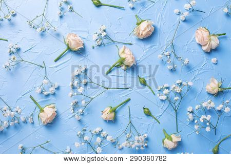 Pattern From Fresh White Gypsofila And Rose  Flowers On Blue Textured Background. Top View. Flat Lay