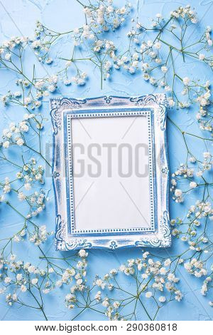 Empty  Vintage Frame And  Fresh White Gypsofila  Flowers On Blue Textured Background. Top View. Flat