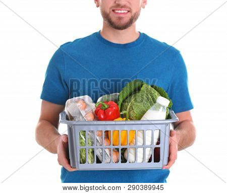 Delivery Man Holding Plastic Crate With Food Products On White Background, Closeup