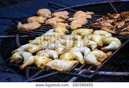 Chicken Pieces Are Baked And Roust On A Grill Above The Volcanic Stone.