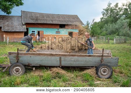 Litynia Village, Ukraine - June 02, 2018: Two 10 Years Old Boys Working Near Hay. Making Stock Hay F