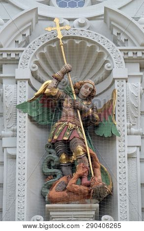 LUCERNE, SWITZERLAND - JUNE 24, 2018: Saint Michael slaying the dragon, statue on the portal of the church of St. Leodegar in Lucerne, Switzerland