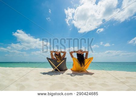 Two Women enjoying their holidays on a transat at the tropical beach in Thailand