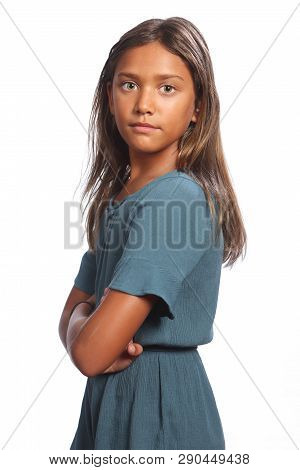 Mixed Race Young School Girl With Green Eyes Wearing Blue Dress Against White Background, Standing W