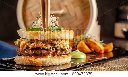 Pan-asian Cuisine Concept. Japanese Sushi Burger Made From Rice Bread, Chicken And Pork Meat Patties