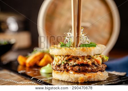 Pan-asian Cuisine Concept. Japanese Sushi Burger Made From Rice Bread, Chicken And Pork Meat Patties