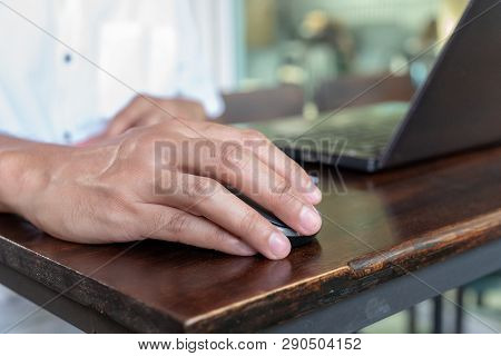 Asian Tan Skin Holding Wireless Mouse On The Vintage Wood Table