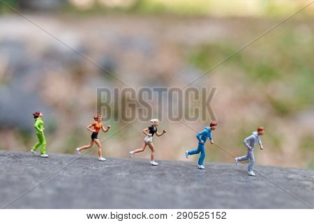 Miniature People Running On The Rock , Health And Lifestyle Concepts.