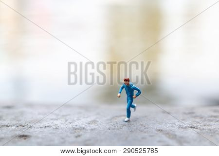 Miniature People Running On The Rock , Health And Lifestyle Concepts.