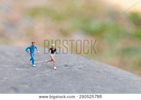 Miniature People Running On The Rock , Health And Lifestyle Concepts.