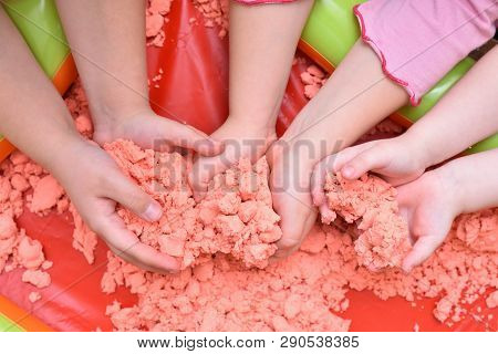 Children Play With Pink Kinetic Sand For Sculpting Figures. Top View, Hands Close Up