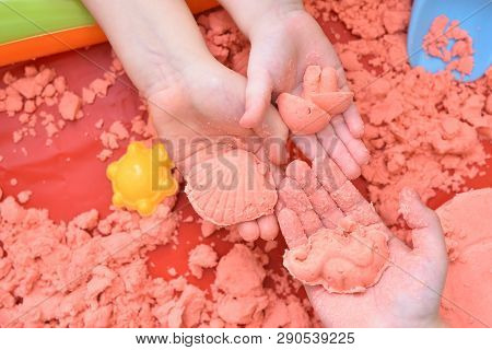 Children Play With Pink Kinetic Sand For Sculpting Figures. Top View, Hands Close Up