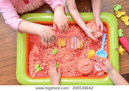 Children Play With Pink Kinetic Sand For Sculpting Figures. Top View, Hands Close Up