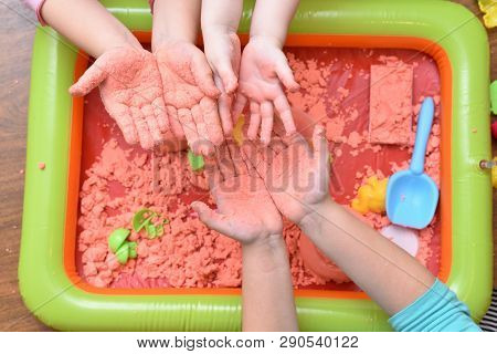 Children Play With Pink Kinetic Sand For Sculpting Figures And Show Their Hands. Top View, Hands Clo