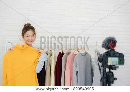 Asian Fashion Female Blogger Online Influencer Holding Shopping Bags And Lots Of Clothes On Clothes 