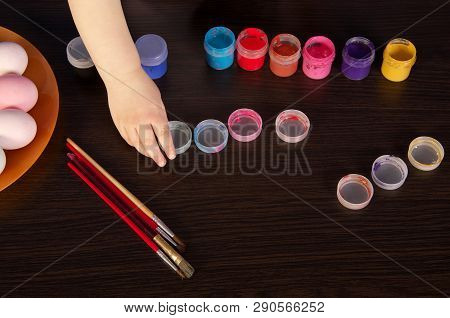 A Child Paints Easter Eggs. Hand, Paintbrush And Paint On The Table. Preparation For Easter.