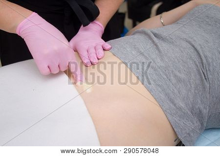 Procedure Of Hair Removing On Leg Beautiful Woman With Sugar Paste Or Wax Honey And Pink Gloves Hand