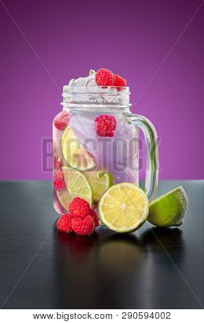 Homemade Violet Lemonade With Berries And Lime On Purple Background