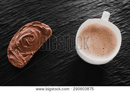 Coffee Cappuccino Or Latte Next To Bread With Chocolate On A Black Background Like Stone Mica