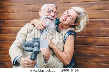 Happy Seniors Couple Recording Video With Gimbal Mobile Phone Outdoor - Mature Fashion People Having