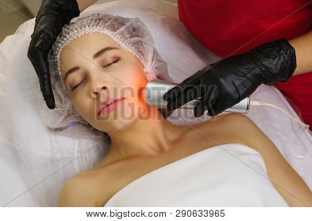 Hardware Cosmetology. Ultrasound Chromotherapy. Beautician Carries Out Procedure For Tightening Skin