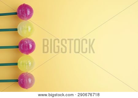 A Lot Of Colorfull Lollipops On A Left. Lollipop On Yellow Background. Copy Space For Text.