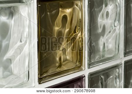 The Wall Is Made Of Colored Glass Blocks. Between The Glass Blocks Made A Dividing Seam. Texture.
