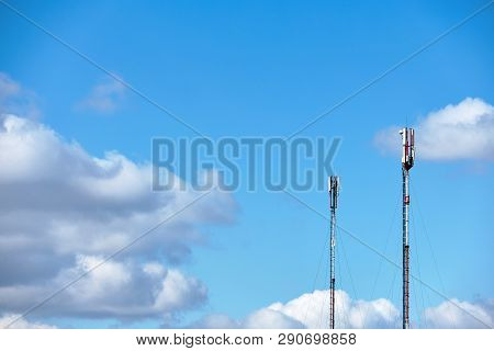 Two Cellular Phone Antennas In The Blue Sky. Technology On The Top Of The Telecommunication Gsm (5g,