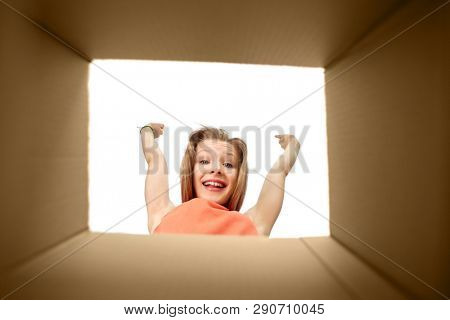 presents and surprise concept - happy girl looking into open gift box
