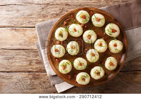 Freshly Made Potato Dumplings With Bacon And Green Onions Close-up On A Plate. Horizontal Top View