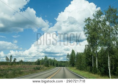 Fields, Trees And Road With Blue Sky And Clouds