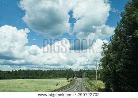Fields, Trees And Road With Blue Sky And Clouds