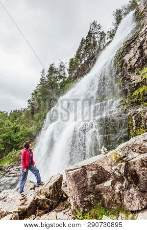 Tourist Woman At Svandalsfossen In Norway, Powerful Waterfall In Norwegian Mountains. National Touri