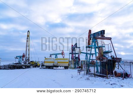 Oil And Gas Industry. Silhouette Oil Pumps On A Sunset Sky Background.oil Industry Equipment. Close 