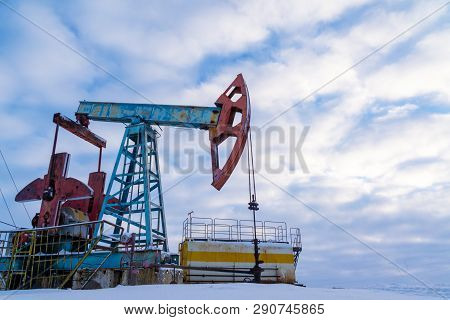 Oil And Gas Industry. Silhouette Oil Pumps On A Sunset Sky Background.oil Industry Equipment. Close 