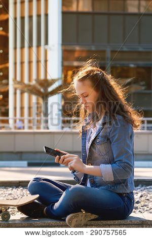 Happy Teen Girl Talk By A Mobile Phone Sit In A City